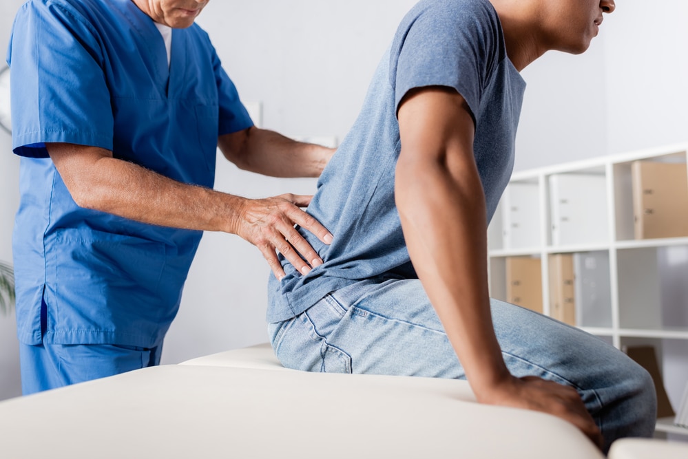 Employee With A Back Injury being seen by a doctor