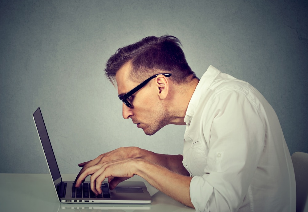 Man Slouched Over Computer