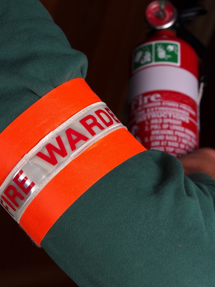 An employee designated as fire warden holding a fire extinguisher.
