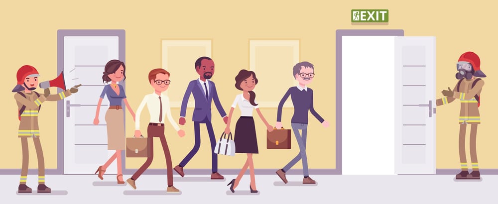 A group of employees walking into an office door during an emergency evacuation drill