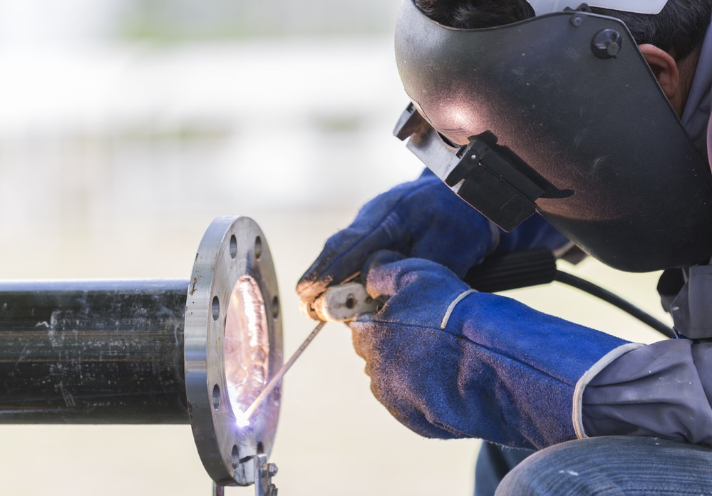 A welder working on a pipe.