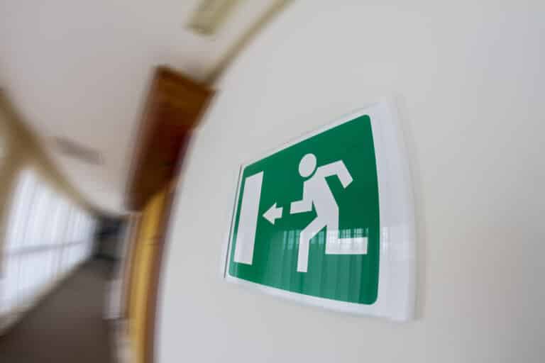 A blurred image of an exit sign in a hallway.