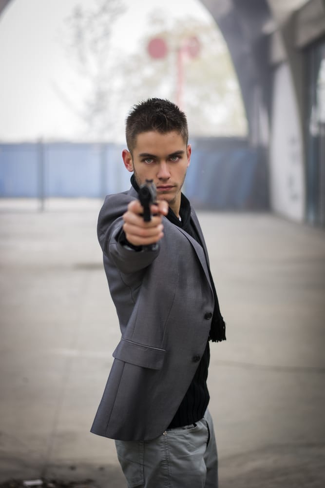 A man holding a gun walking toward a business