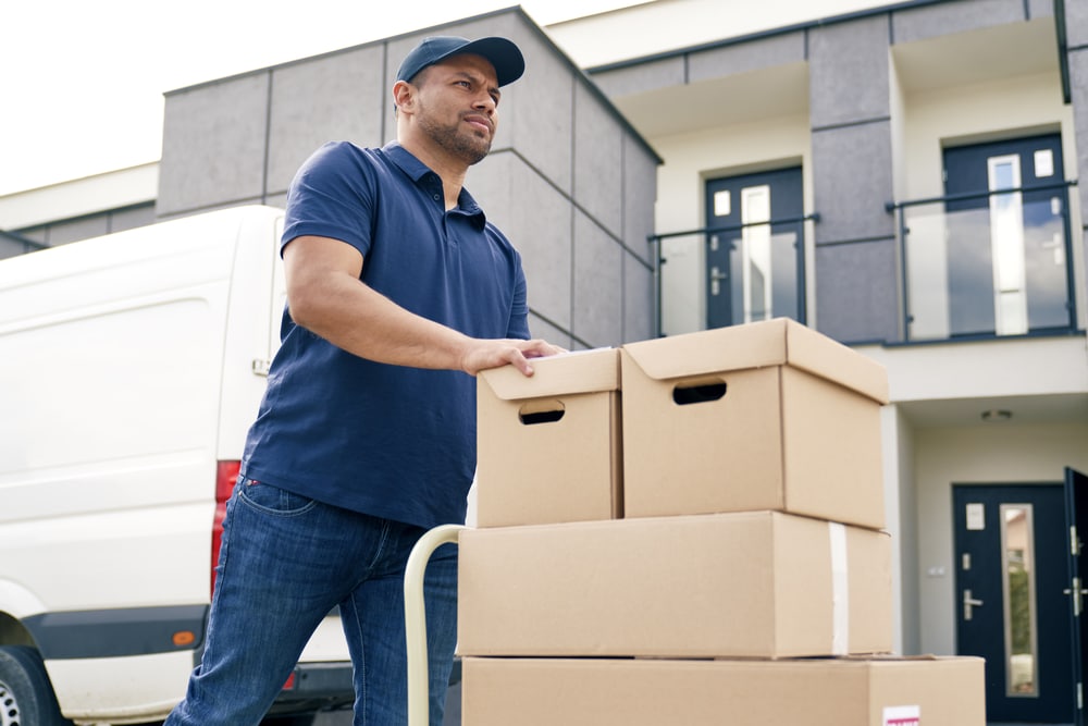 A man loading boxes into a moving truck.