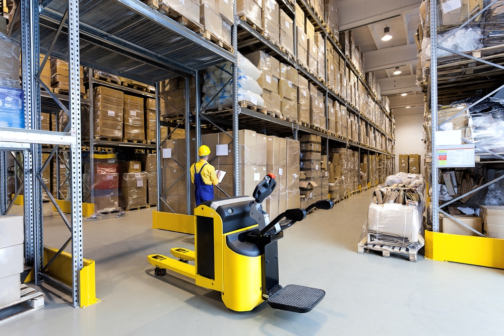 A yellow walkie stacker forklift in a warehouse.