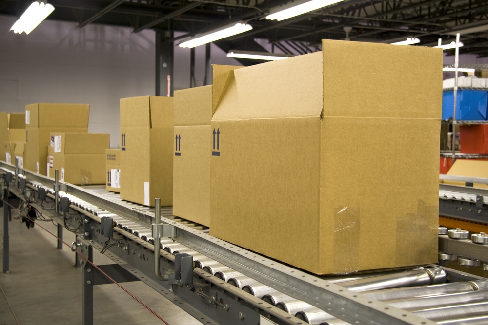 A conveyor belt in a warehouse with boxes traveling along
