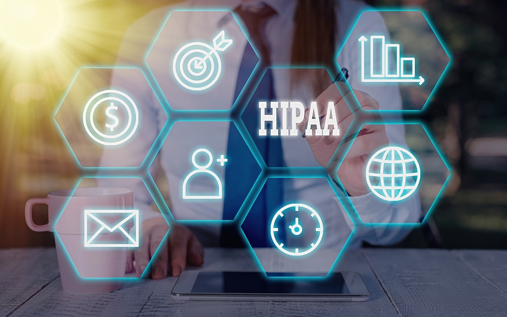 A woman is sitting at a computer with the words hipaa on it.