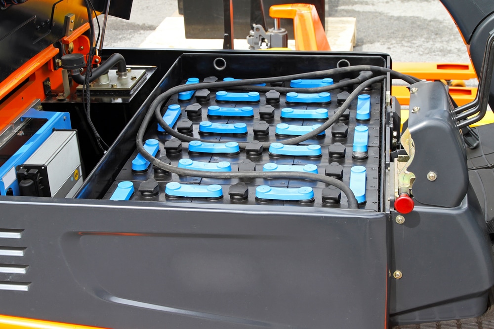 A black and orange forklift with a battery compartment.